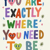 Colorful motivational quote "You are exactly where you need to be" with smiley faces on a white background